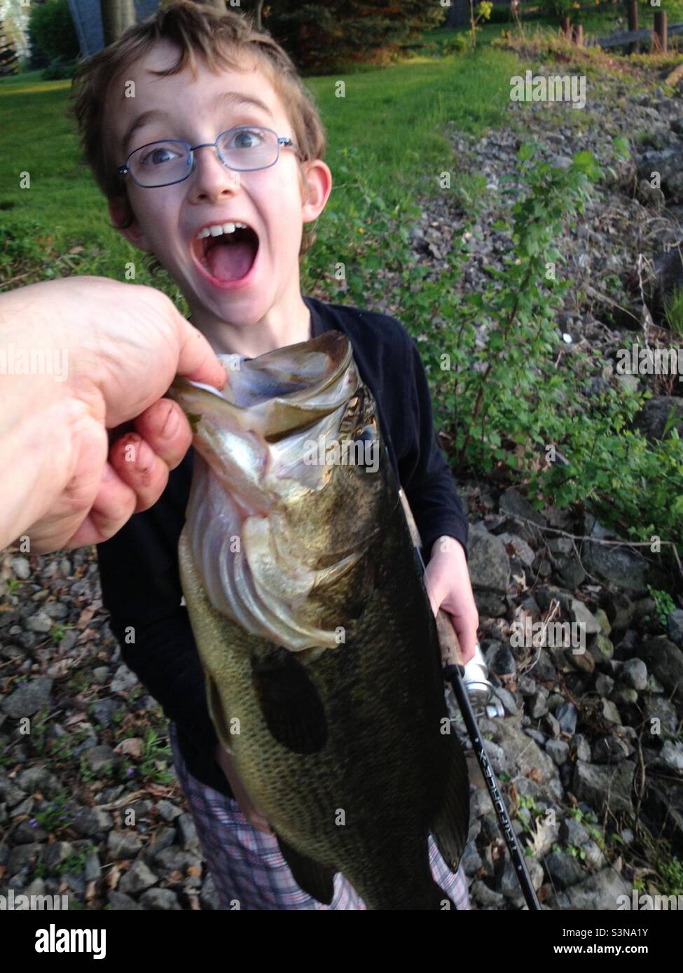 Who has a bigger mouth? Fishing with my son. - Smartphone Captured Stock Image
