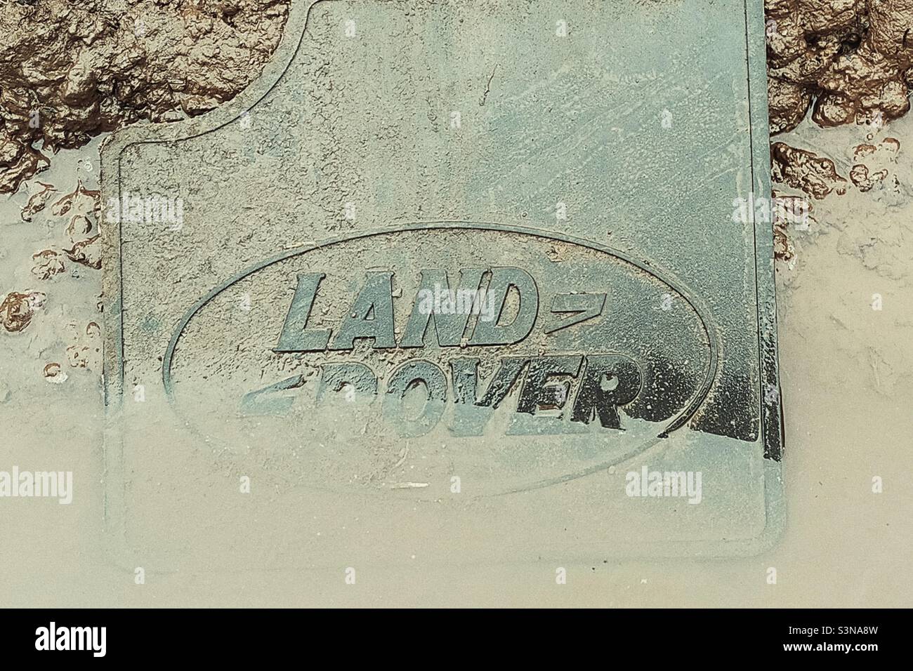 Land Rover mudflap in muddy puddle. - Smartphone Captured Stock Image