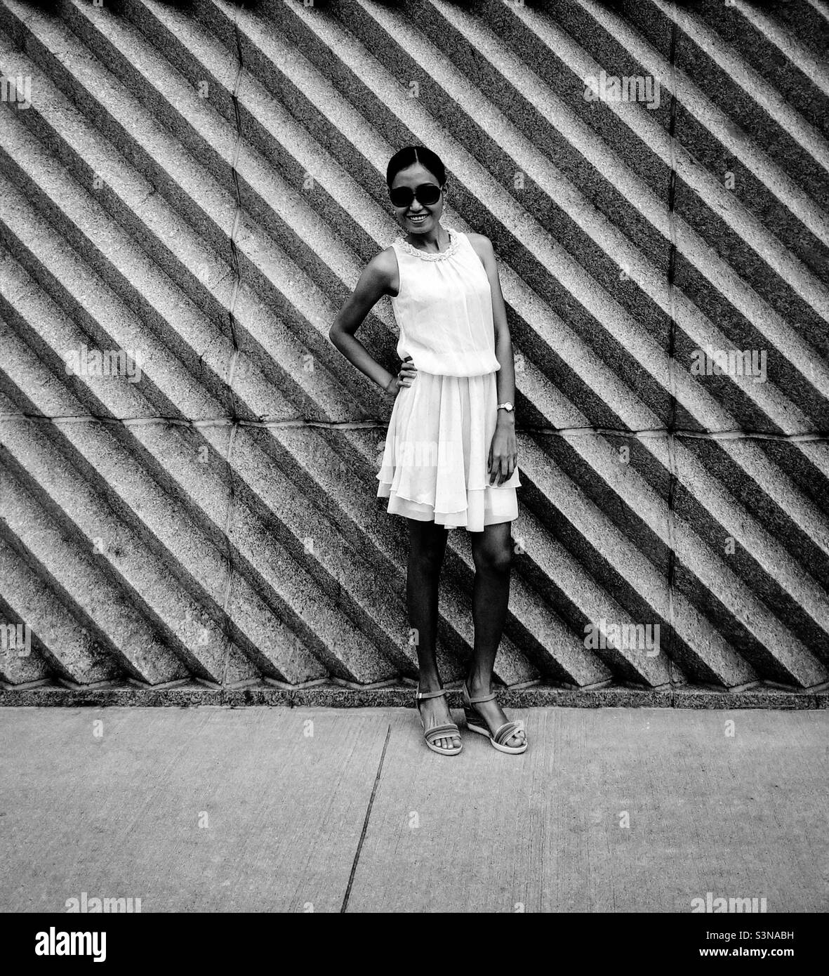 A woman smiling against the wall - Smartphone Captured Stock Image