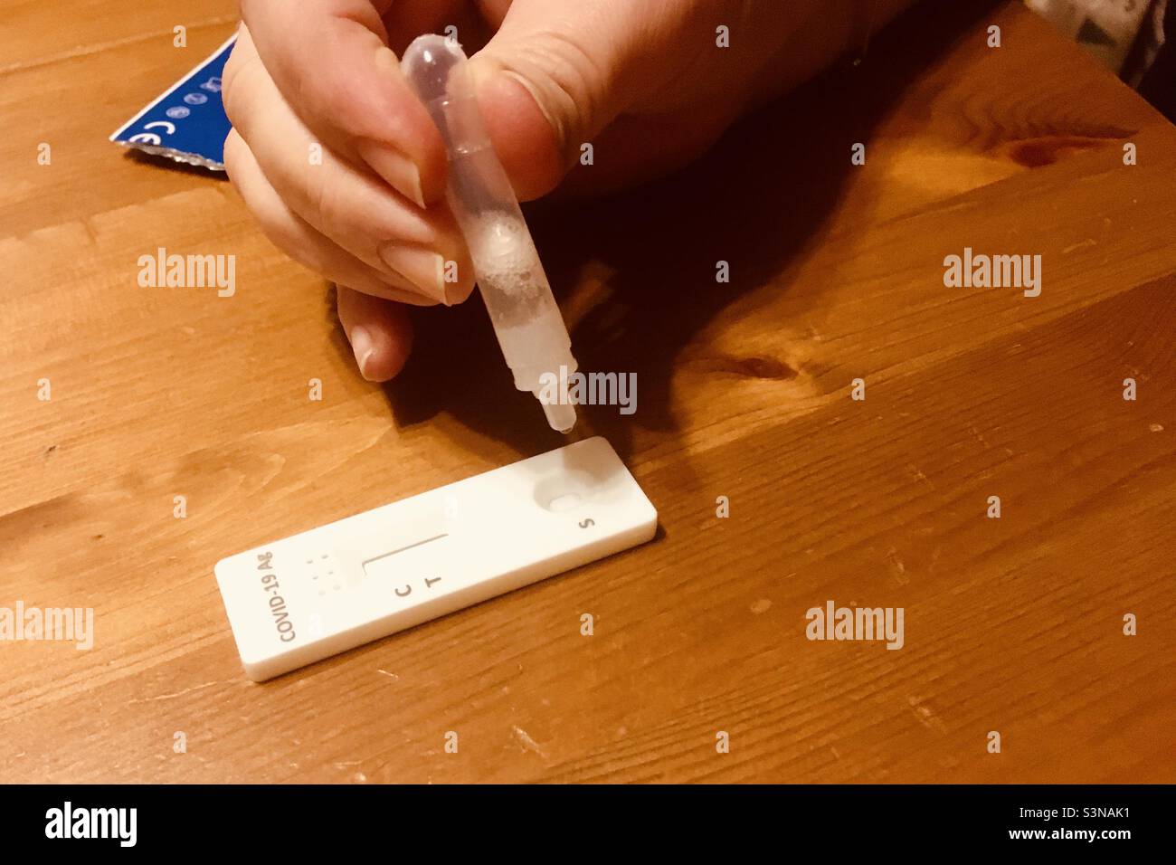 COVID-19 antigen rapid test, dripping saliva onto device - Smartphone Captured Stock Image