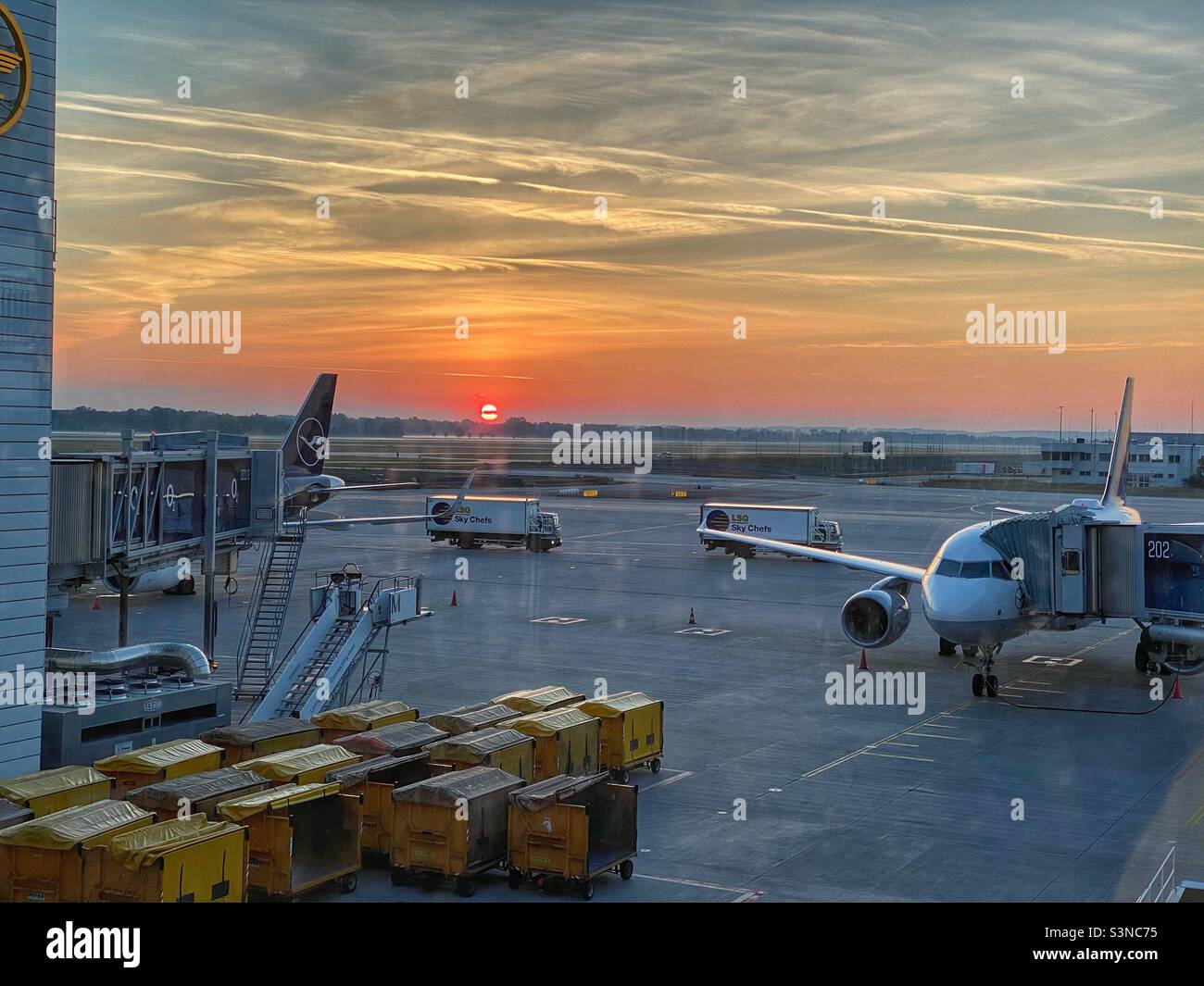 Orange-colored sunrise at Munich Airport, Germany. - Smartphone Captured Stock Image