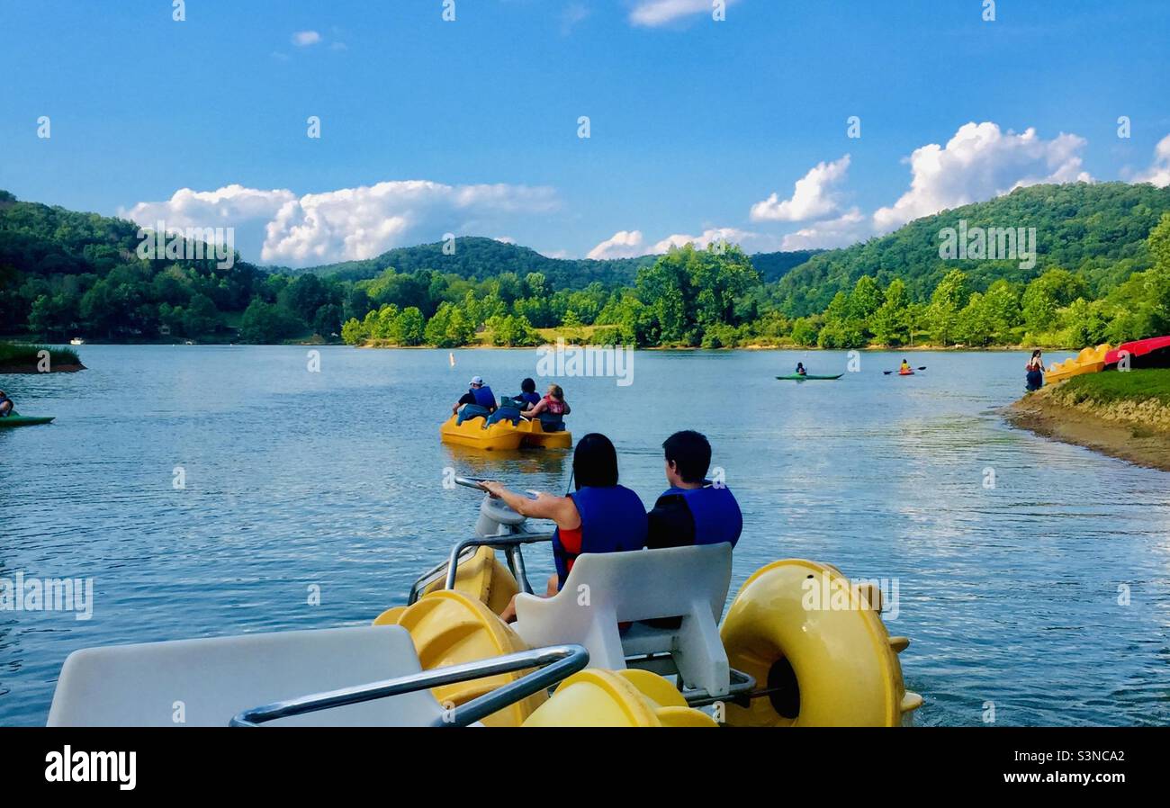 Summer day on a lake, water recreation, family outdoor activities, adventure and exploring, kayaking, paddle boats, water bike Stock Photo