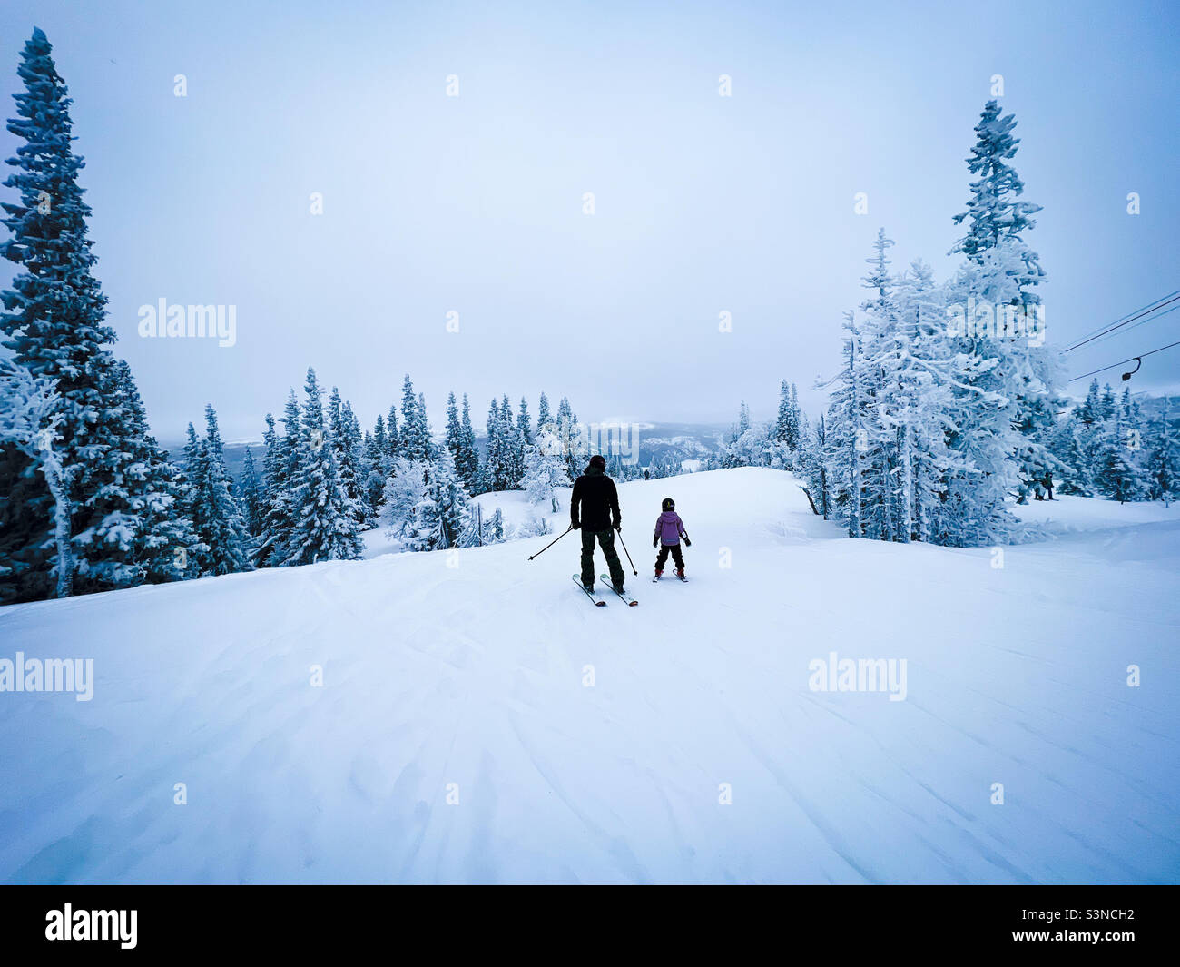 Father and child skiing in white winter wonderland - Smartphone Captured Stock Image