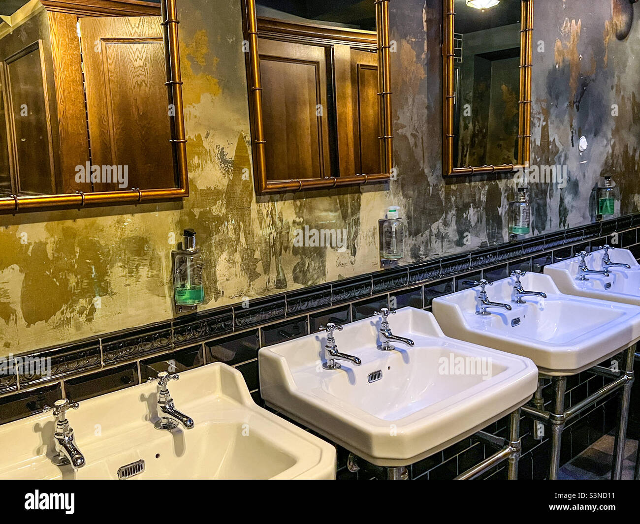 Trendy old fashioned wash sinks in bar toilets Stock Photo