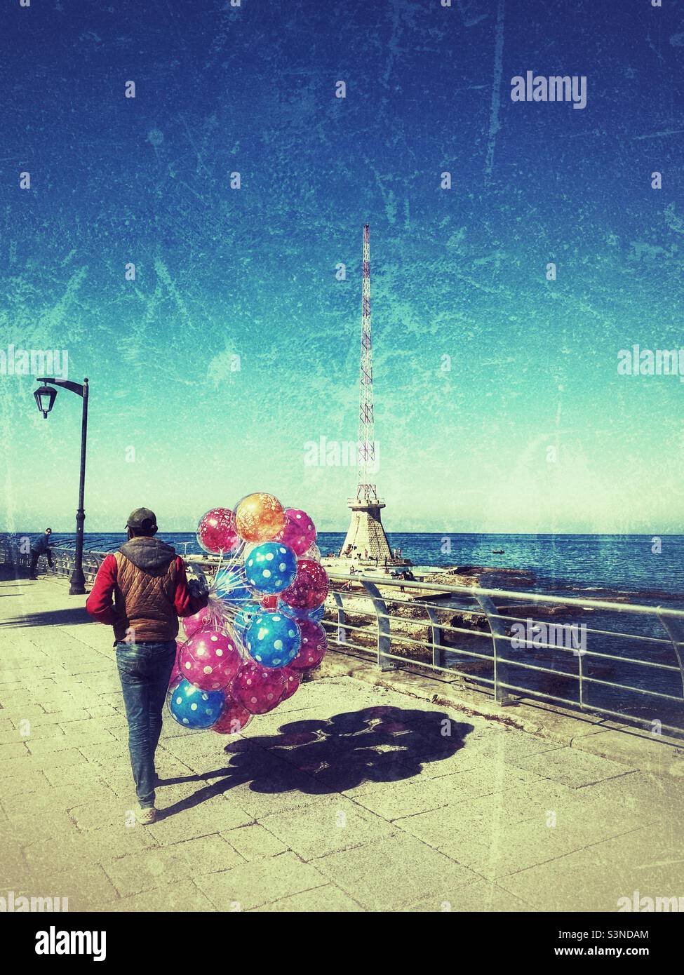 Colorful balloons sellier walking in Beirut Lebanon promenade in a sunny day Stock Photo