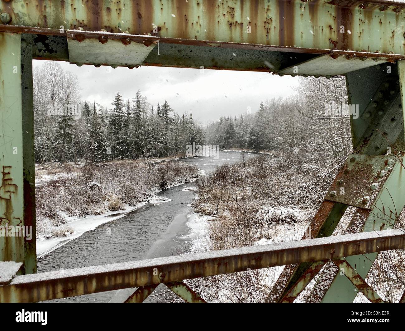 Sacandaga River in winter framed by an old rusted highway bridge Stock Photo