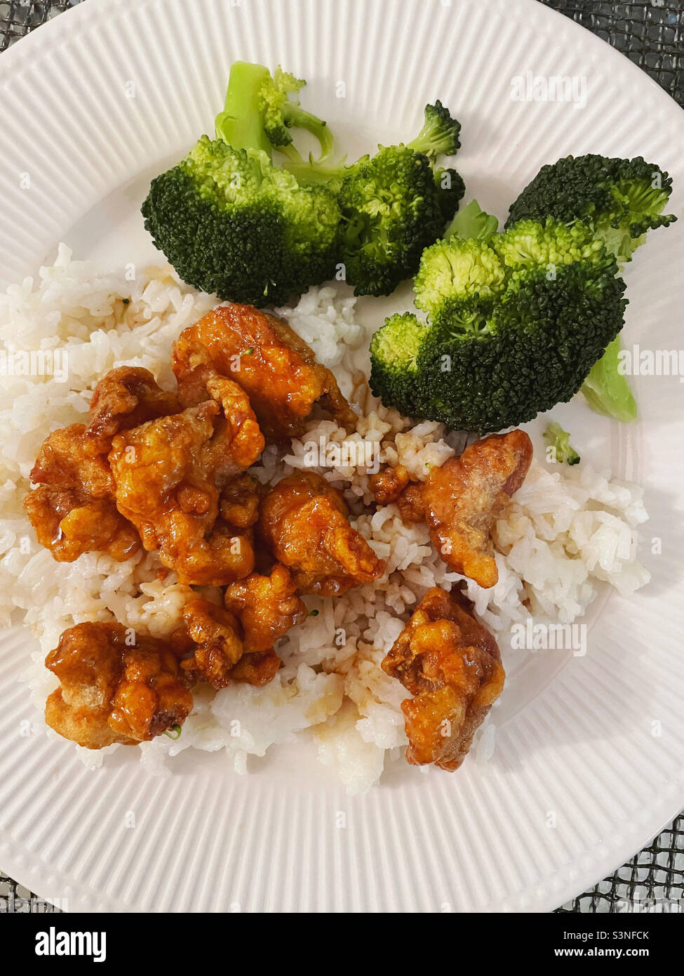 Close-up of a Chinese cuisine meal of Mandarin orange chicken served over white rice with a side of broccoli, 2022, USA - Smartphone Captured Stock Image
