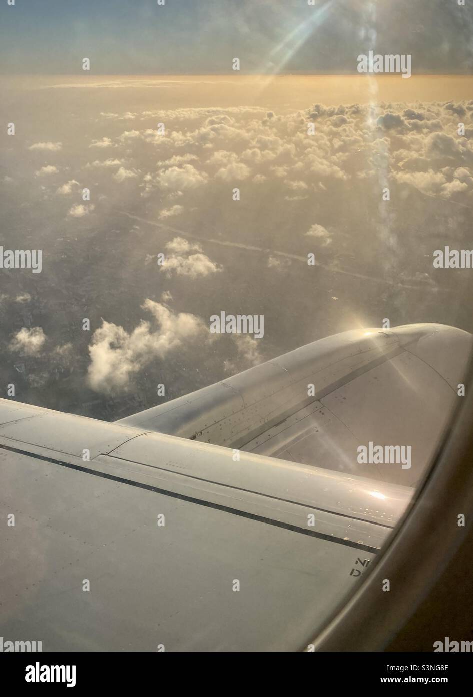 The directional sunlight reflects on the clouds and Airplane - Smartphone Captured Stock Image