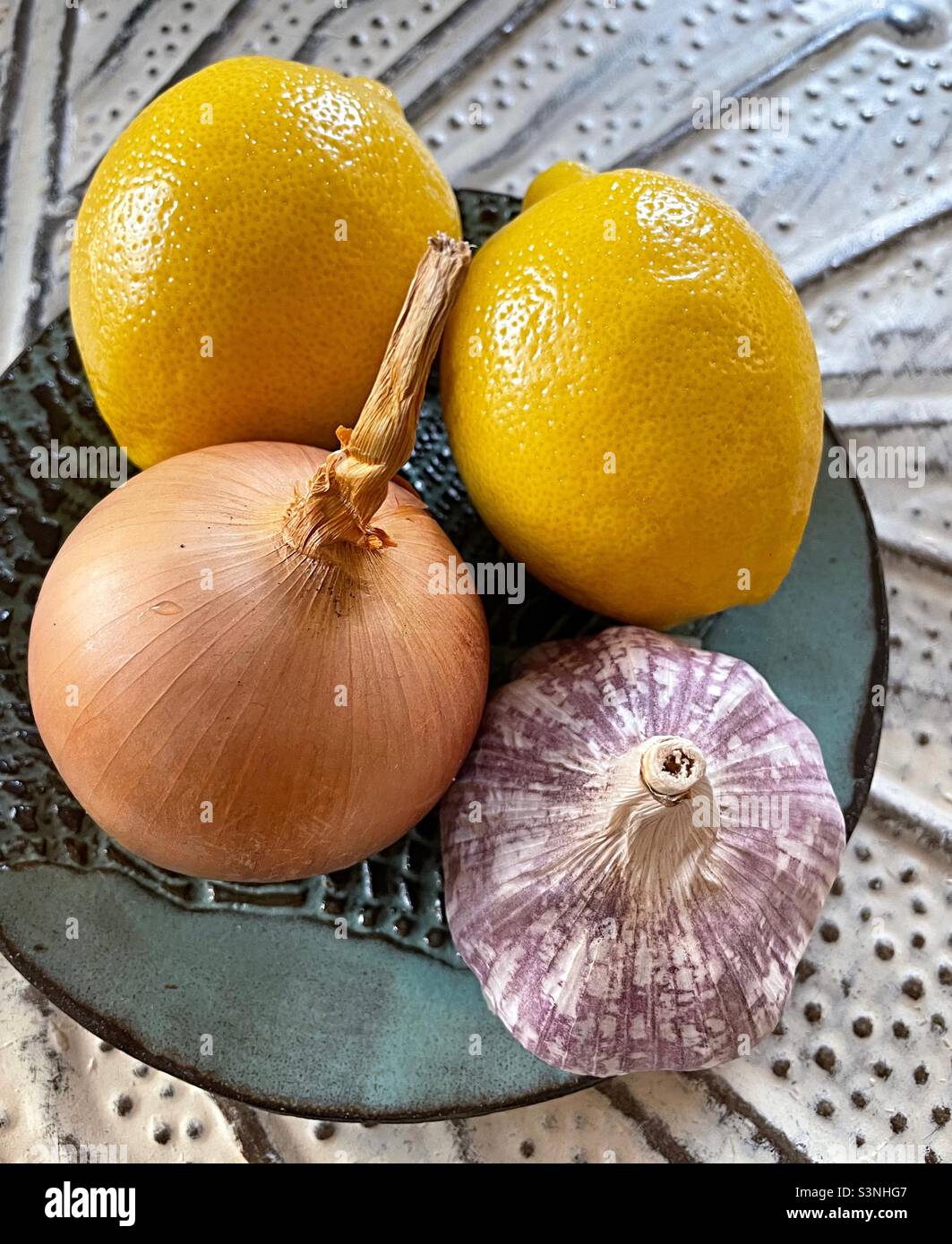 Close up of a plate with lemons, onion and garlic - Smartphone Captured Stock Image