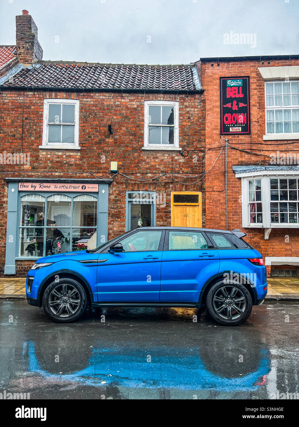 Bright blue Range Rover Evoque car parked on road in urban village Stock Photo