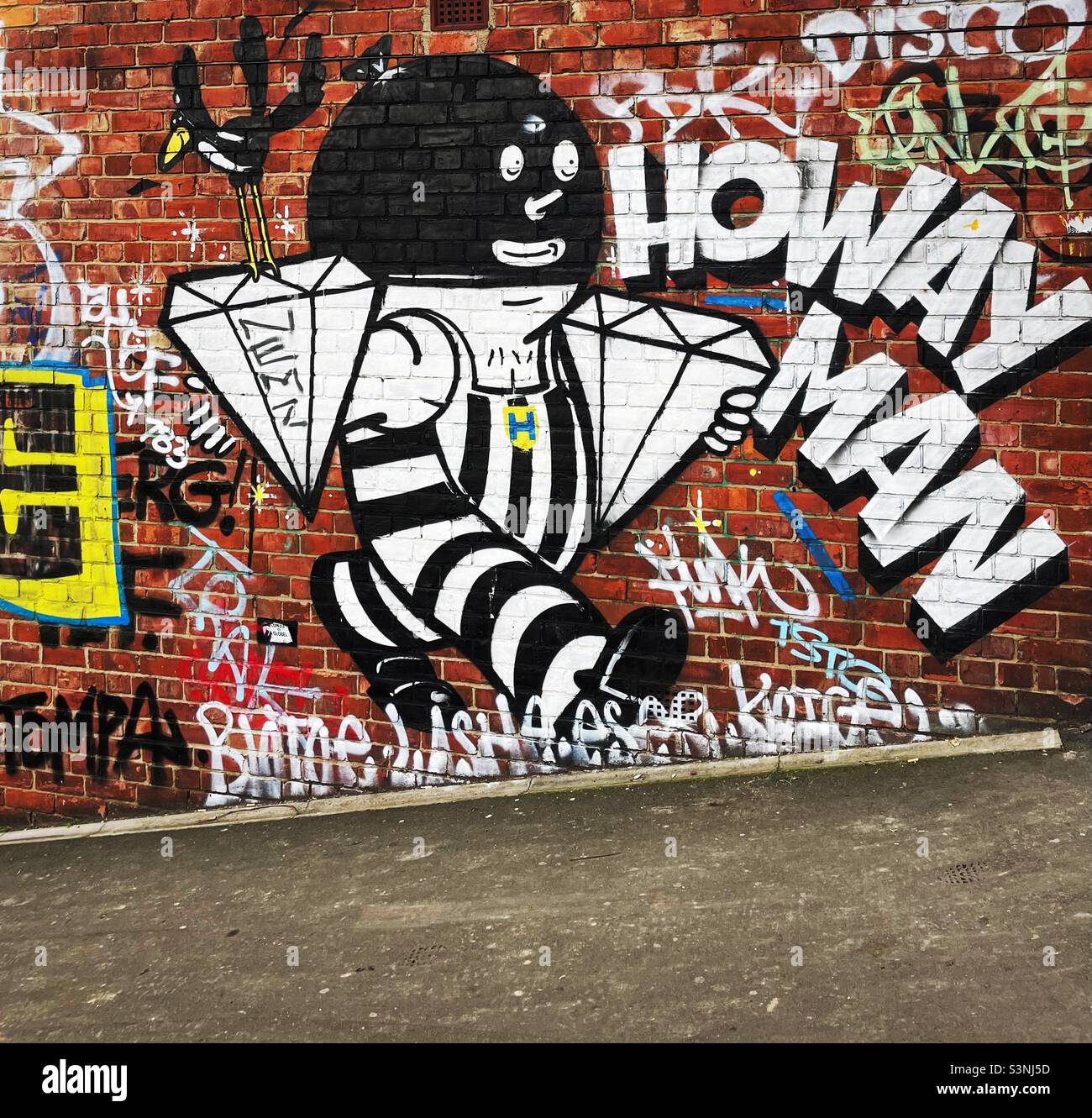 ‘Howay Man’ street art graffiti on a red brick wall in Ouseburn