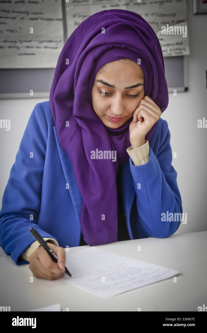 Young Asian student wearing a purple headscarf, studying Stock Photo