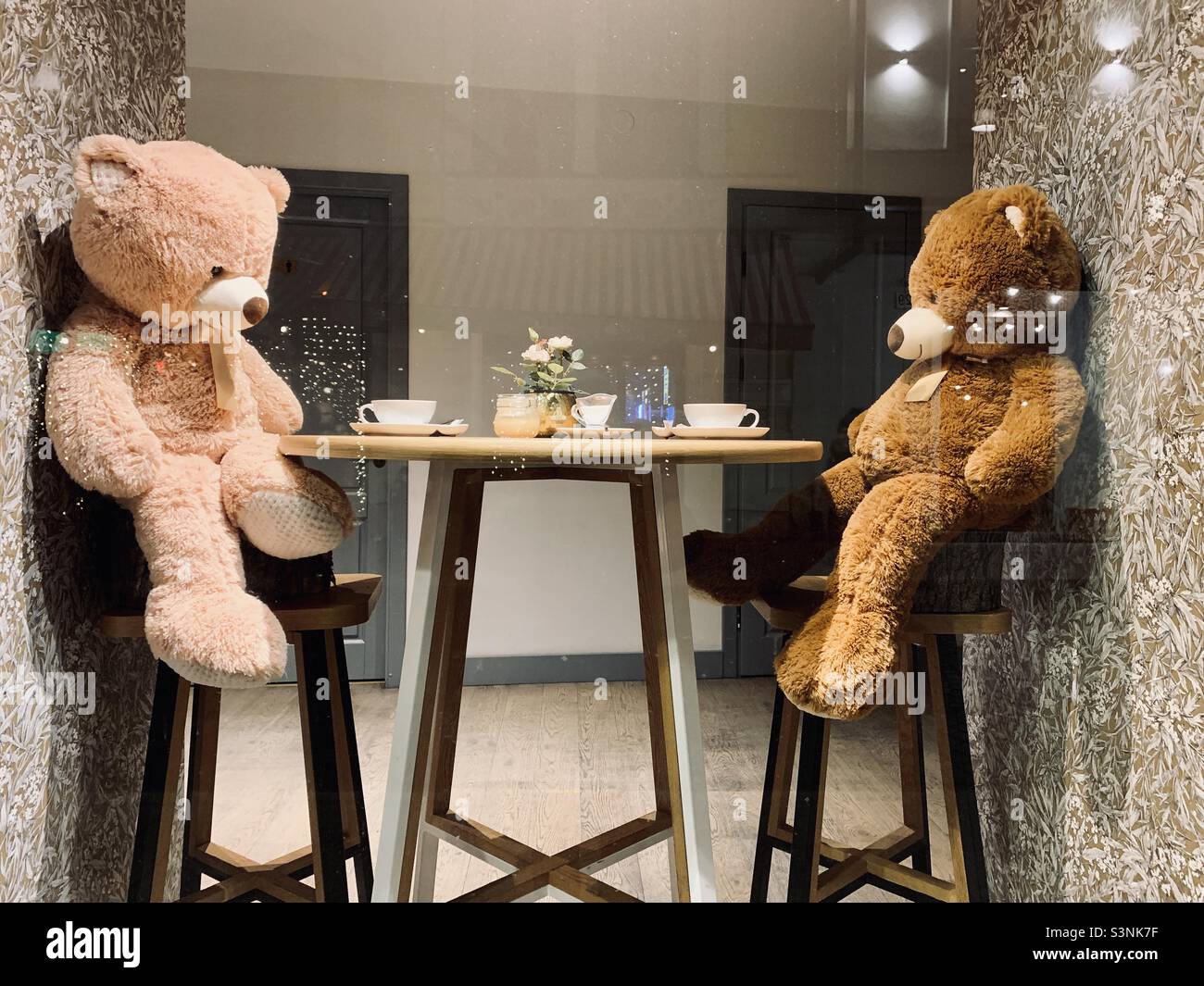 Cafe window with two toy bears sitting at table - Smartphone Captured Stock Image