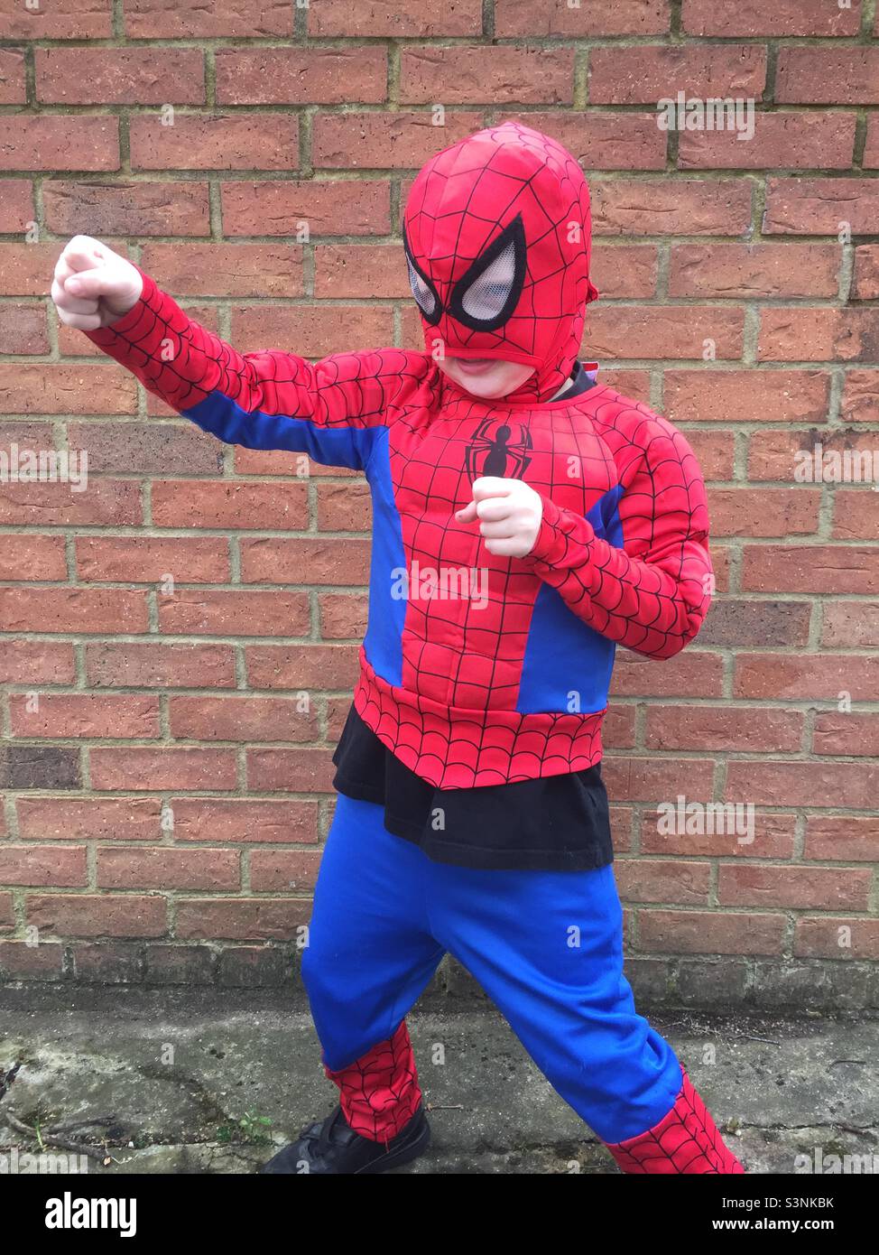 Boy dressed as spider man punching Stock Photo Alamy