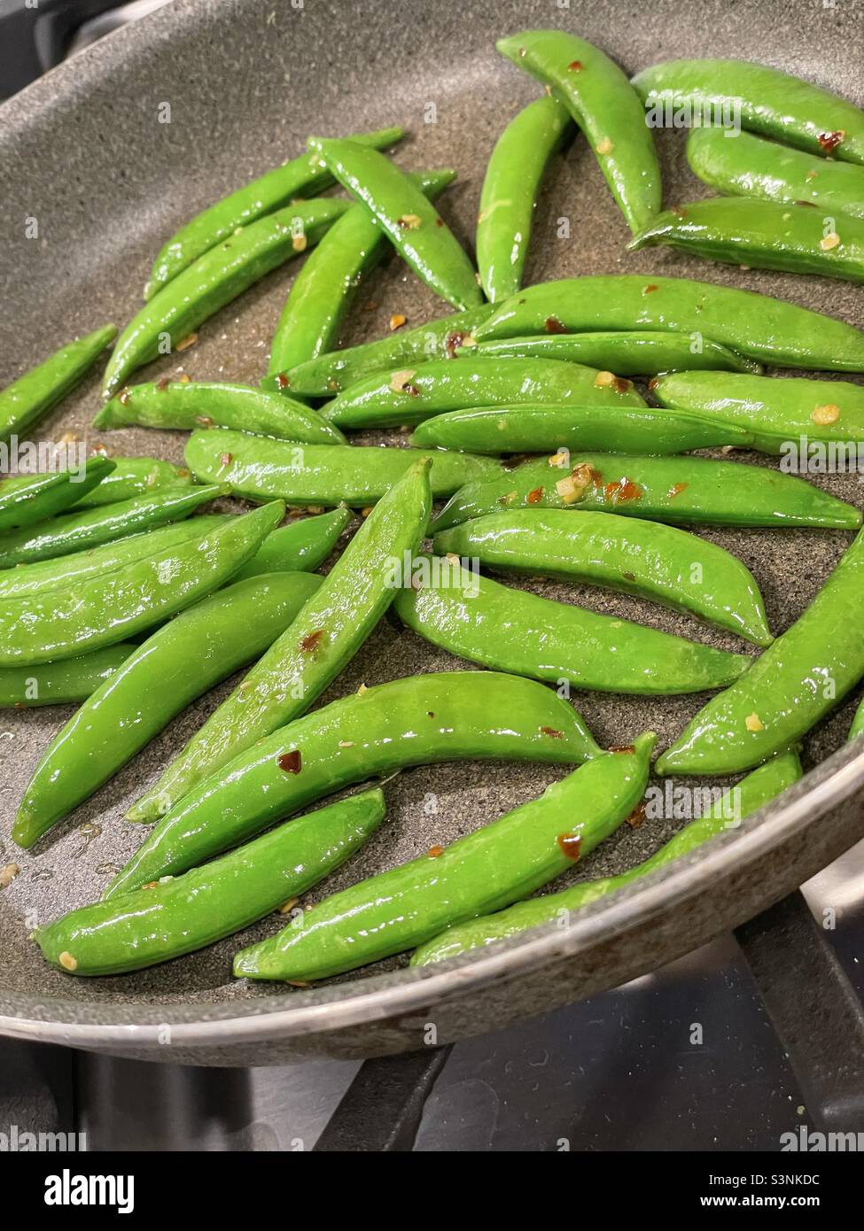 Fresh sugar snap peas in the sauté pan - Smartphone Captured Stock Image