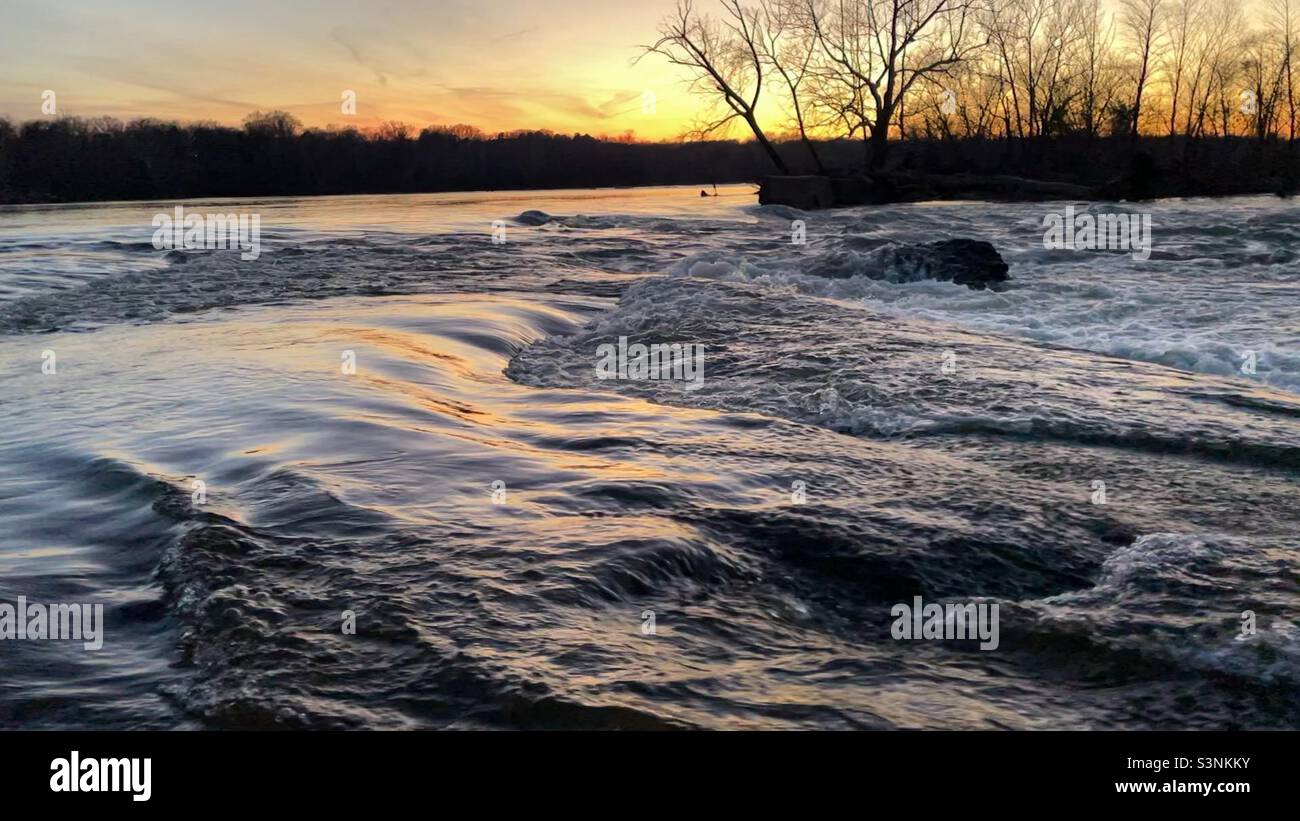Small river rapids at sunset during a winter sunset. Stock Photo