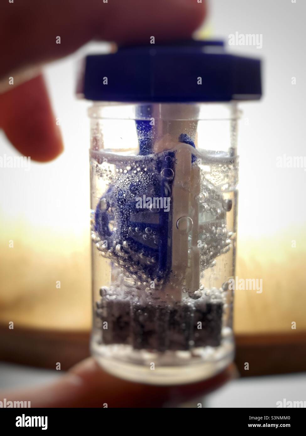 A person holding a contact lenses container - Smartphone Captured Stock Image