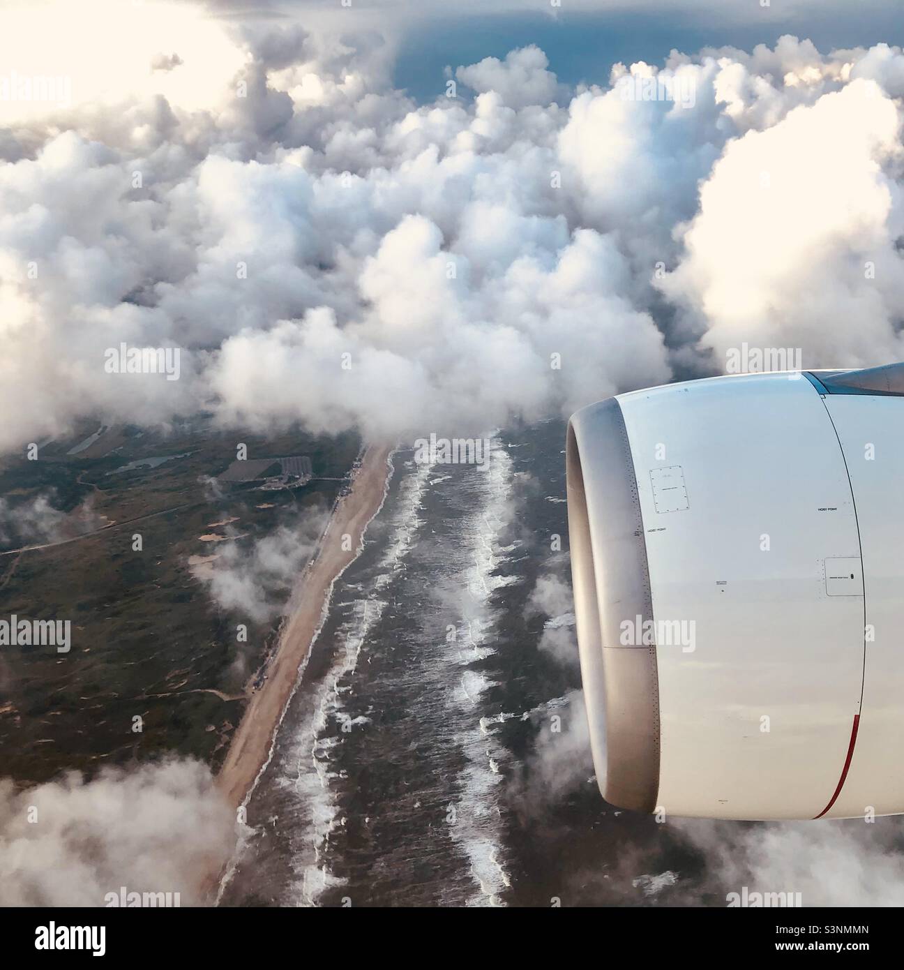Amsterdam - view of the coast from the sky - beach, sea and clouds. Plane reactor foreground during the flight - Smartphone Captured Stock Image