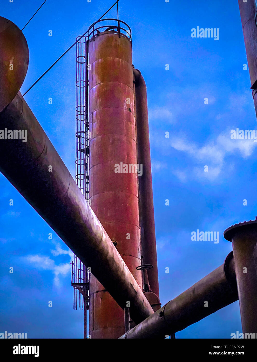 Pipes and exhaust towers from a defunct industrial steam works plant Stock Photo