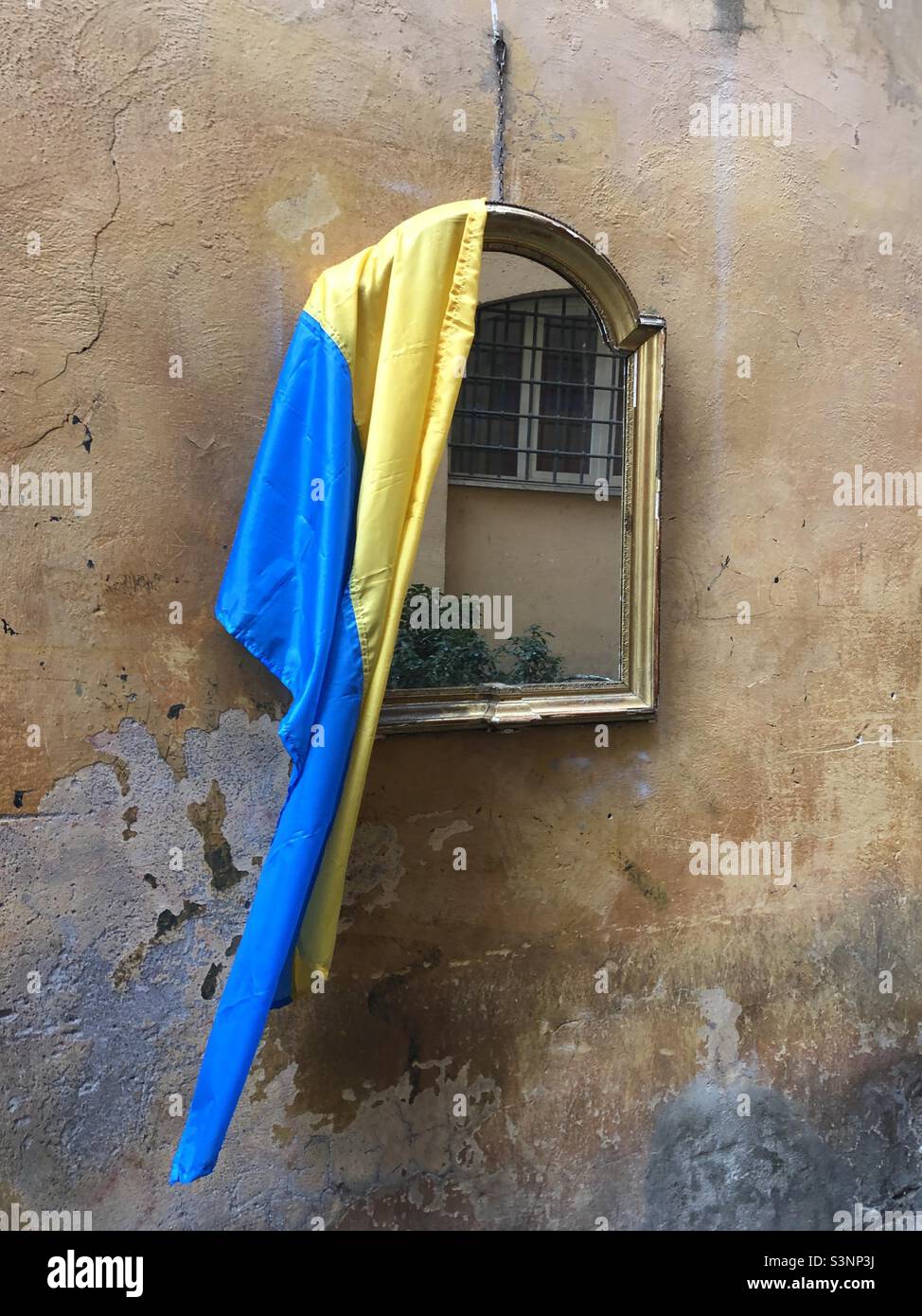 Ukrainian flag left on a mirror on a wall in the streets of Rome Italy - Smartphone Captured Stock Image
