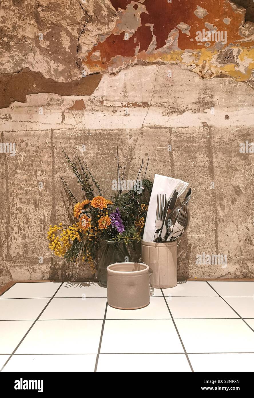 Set café table with natural wall and wild flowers Stock Photo