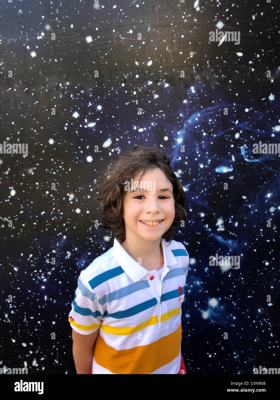 Ten year old boy enjoying a space background picture - Smartphone Captured Stock Image