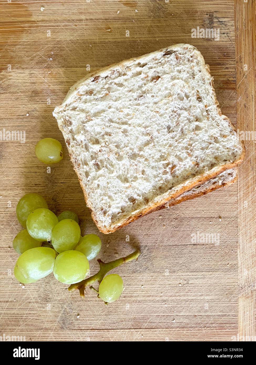 Sandwich and grapes on wooden board - Smartphone Captured Stock Image