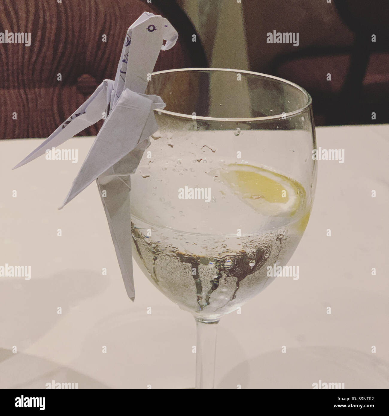 Origami bird on a water glass, Black Crab Restaurant, MSC Divina cruise ship - Smartphone Captured Stock Image