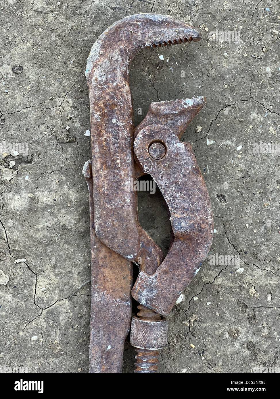 Rusty adjustable Jaw Pipe Wrench on the ground - Smartphone Captured Stock Image