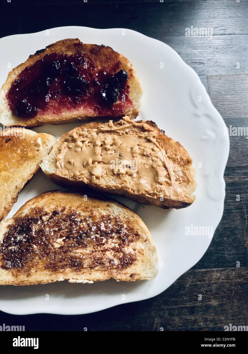 A quadruple of toast toppings blackcurrant jam, peanut butter, yeast