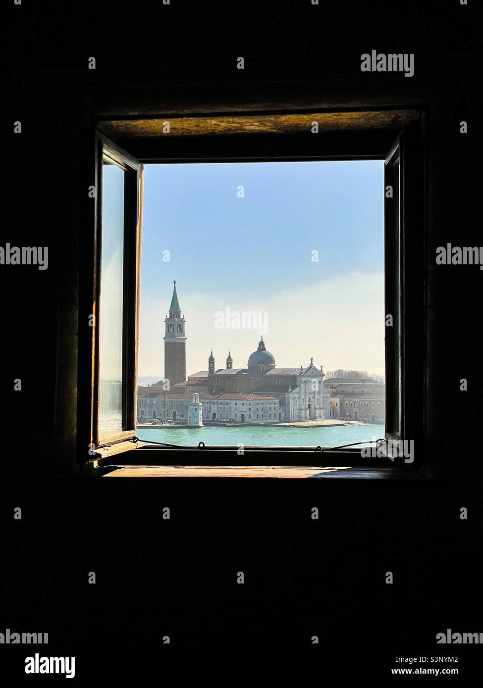 Open window at the Palazzo Ducale (Doge’s Palace) in Venice, overlooking San Giorgio Maggiore on a sunny February day. Stock Photo