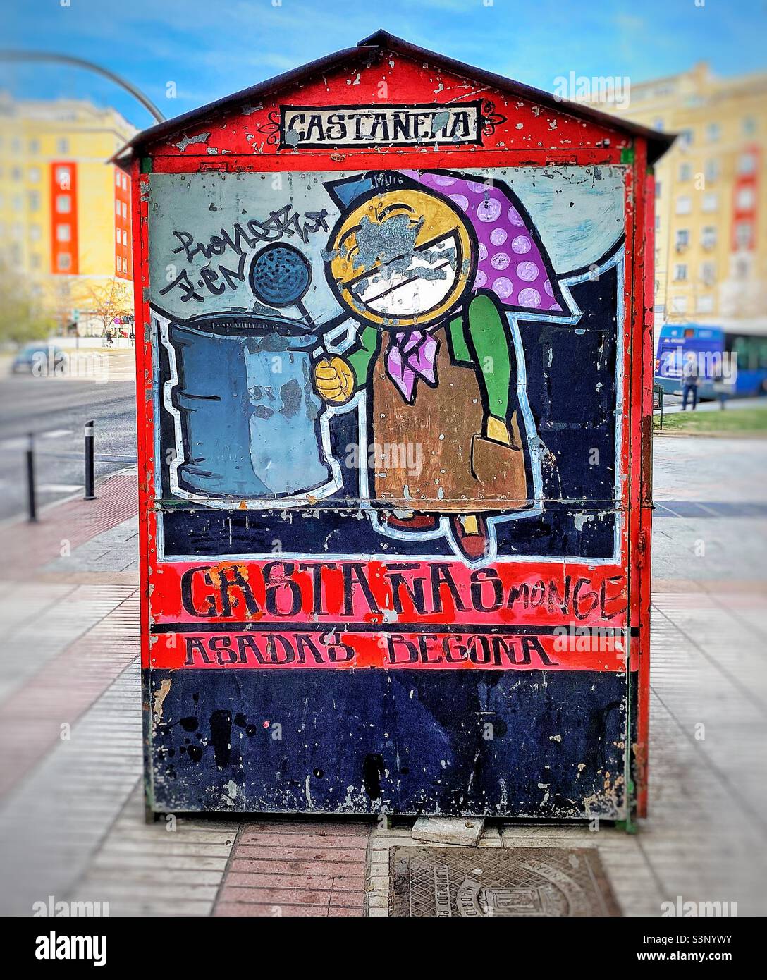 A colourfully painted cabin where roast chestnuts are sold to passers by on the pavement in a busy street in Madrid , Spain - Smartphone Captured Stock Image