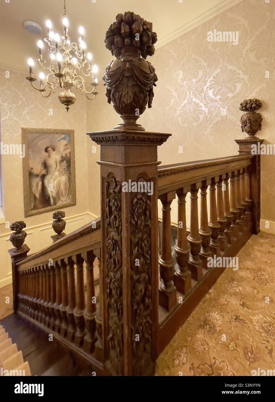 A fine carved oak staircase with finials in the form of baskets of fruit at Hintlesham Hall in Suffolk UK - Smartphone Captured Stock Image
