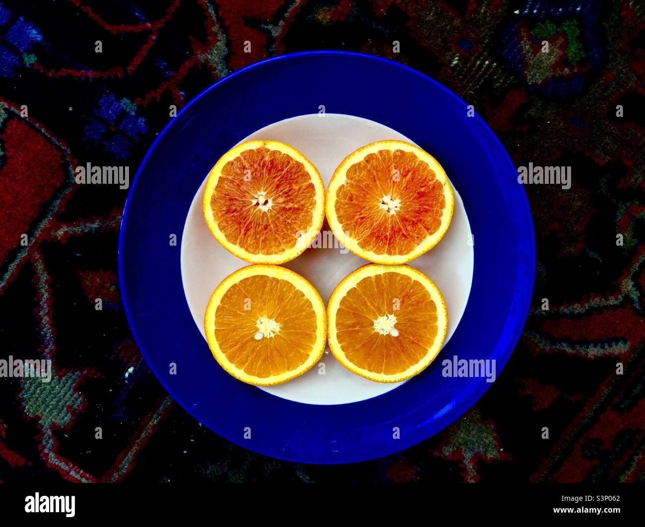 Juicy, nourishing Pink grapefruit, arranged in a circle of circles. Round halves in a round bowl on a richly coloured orientalists rug. - Smartphone Captured Stock Image