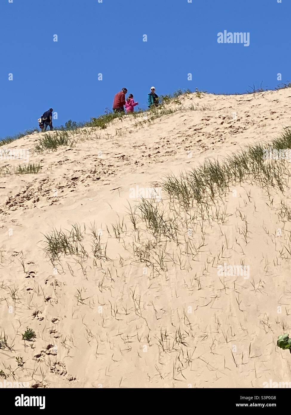 An upward shot of climbers ascending sleeping bear dunes Michigan Stock Photo