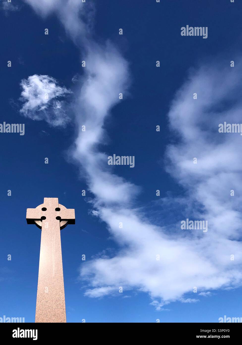Gravestone against a blue sky Stock Photo