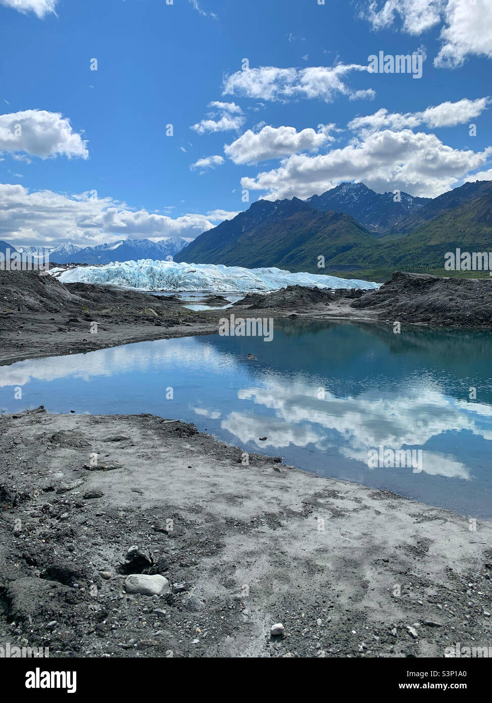 Matanuska Glacier in the summer with glacial lake and mountains of Alaska in the background. Stock Photo