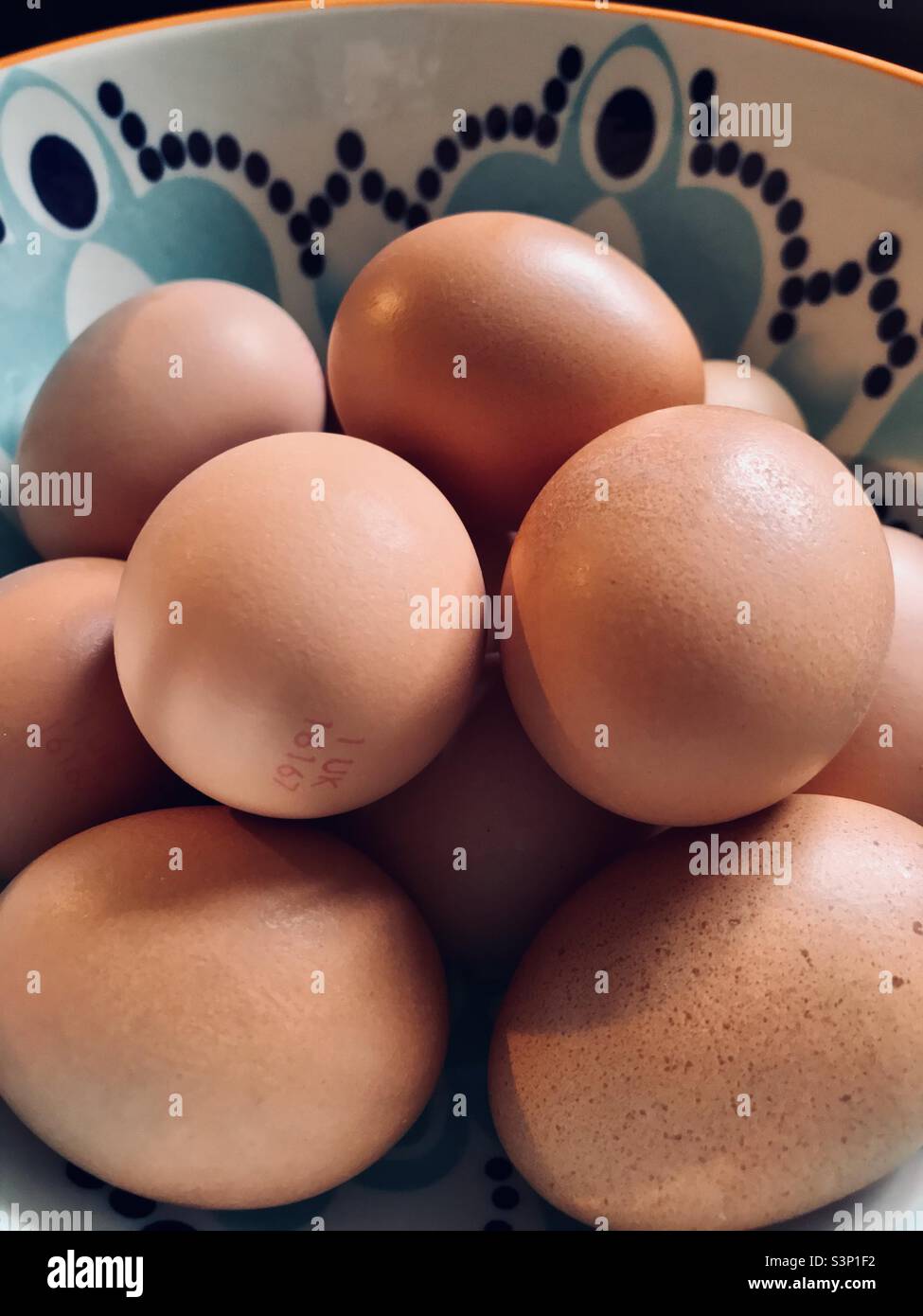 Close up shot of a dozen eggs in a decorative bowl Stock Photo
