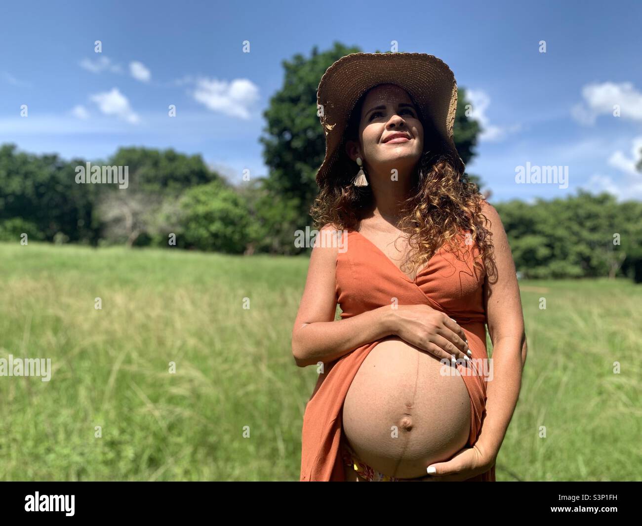 8 month pregnant woman caresses her belly, which shows the linea nigra. Pregnancy expectations. Stock Photo