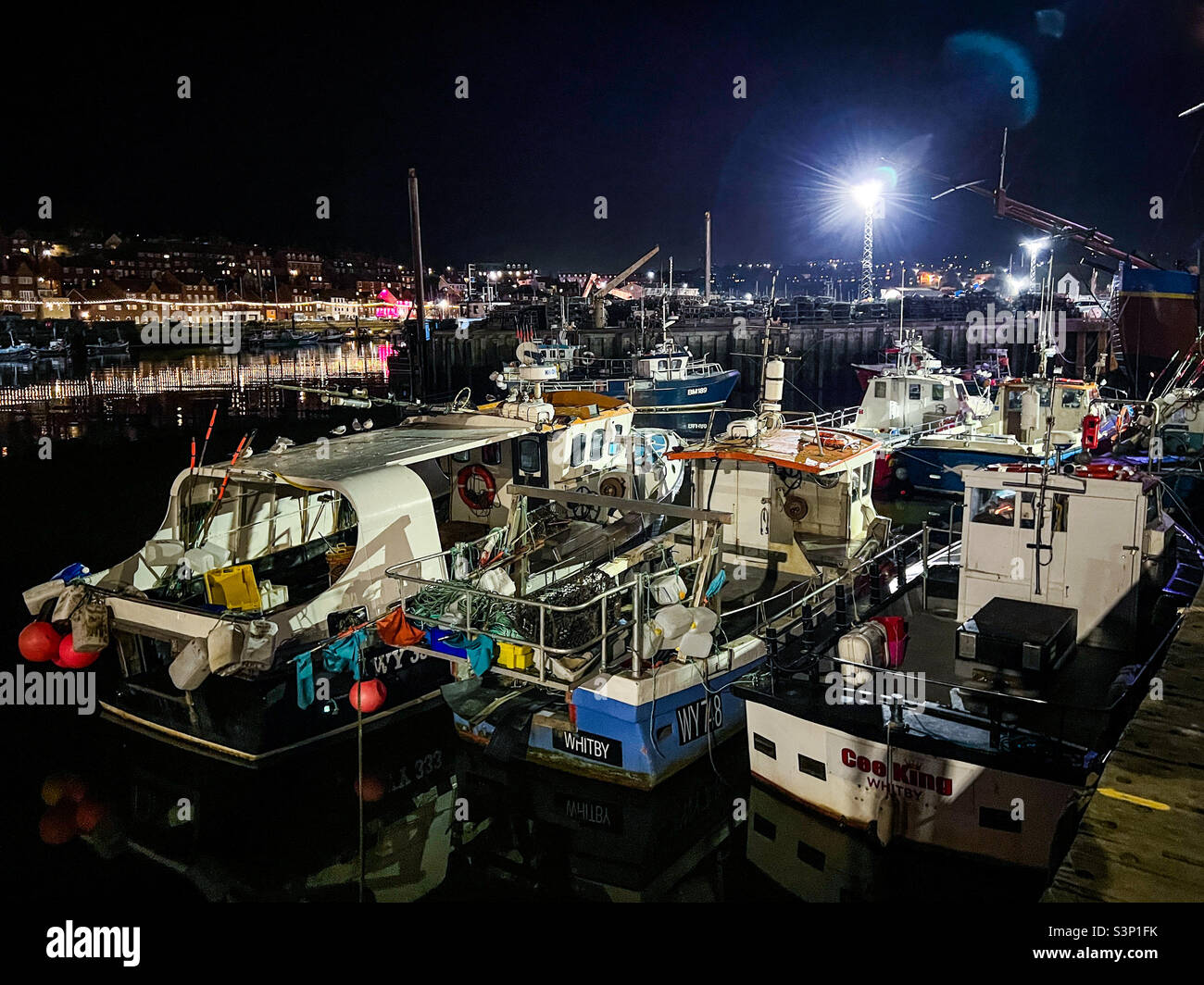 Fishing boats moored on the river esk in Whitby North Yorkshire at night - Smartphone Captured Stock Image