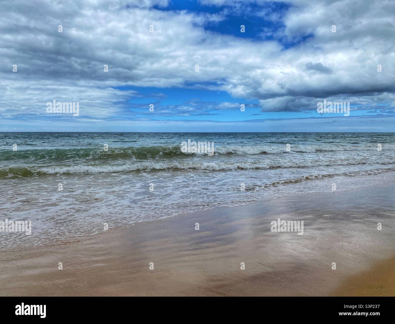 Ocean waves with cloud reflections on Praia da Falesia beach in Algarve, Portugal. - Smartphone Captured Stock Image