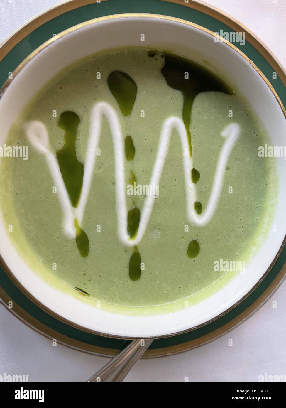 Green soup with oil and cream topping - Smartphone Captured Stock Image