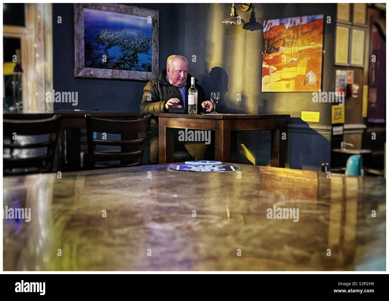 Man drinking a bottle of wine alone in a London pub - Smartphone Captured Stock Image