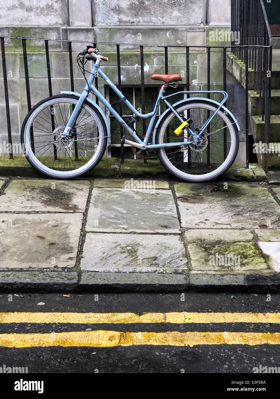 Old style bicycle chained to railings in the street - Smartphone Captured Stock Image