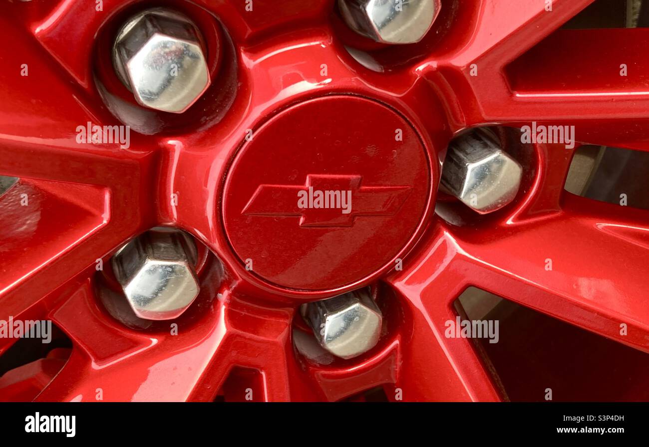 Chevrolet painted red wheel and centre cap with chrome wheel lugs - Smartphone Captured Stock Image