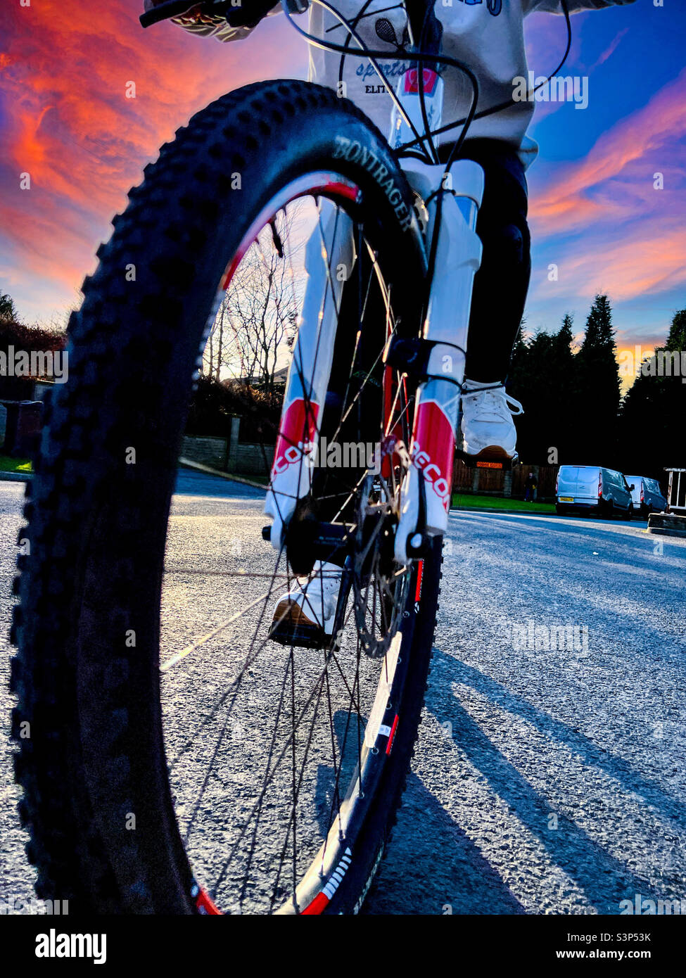 Close up of mountain bike cycling on road at dusk - Smartphone Captured Stock Image
