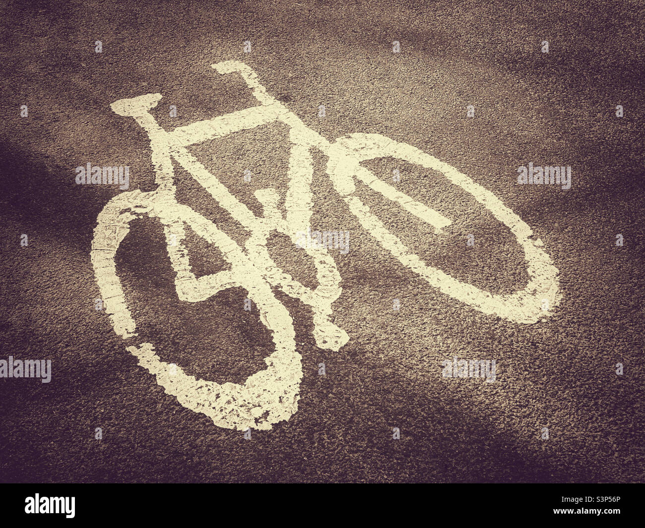 A retro effect image of a painted bicycle on an asphalt surface. This generally indicates an area where bicycles are permitted. Usually a bicycle lane on a road. Photo ©️ COLIN HOSKINS. - Smartphone Captured Stock Image