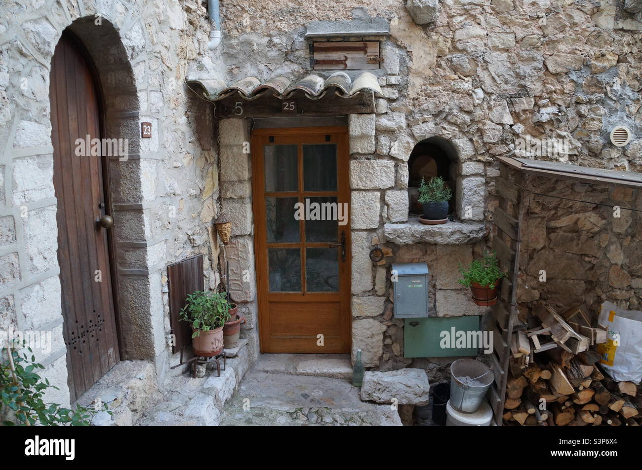 Brown wooden door on a home in the medieval town of Gorbio. - Smartphone Captured Stock Image