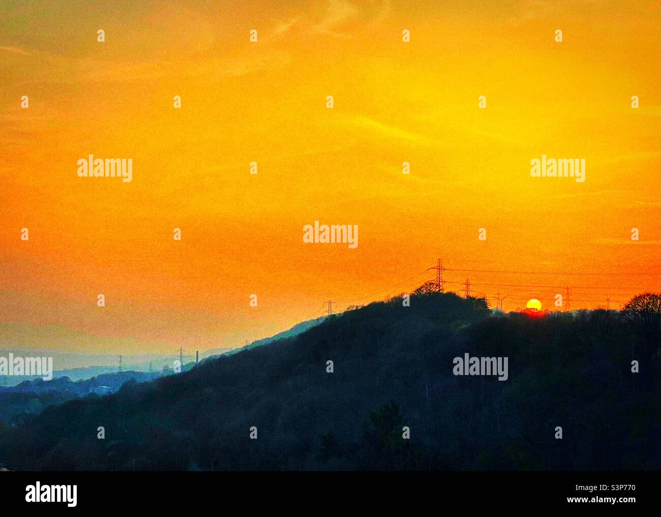‘Pastel Sunset’ the falling sun casts an orangey glow over the hills of Yorkshire on an early Spring evening Stock Photo