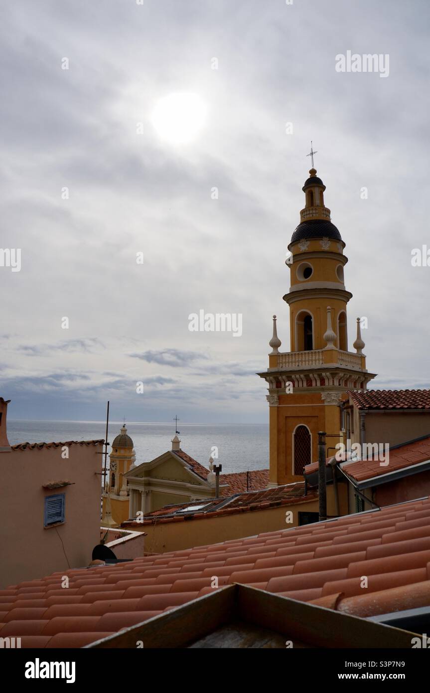 The bell tower of the Basilica of Saint Michael Archangel with the sun trying to breakthrough the clouds as seen from my terasse. - Smartphone Captured Stock Image